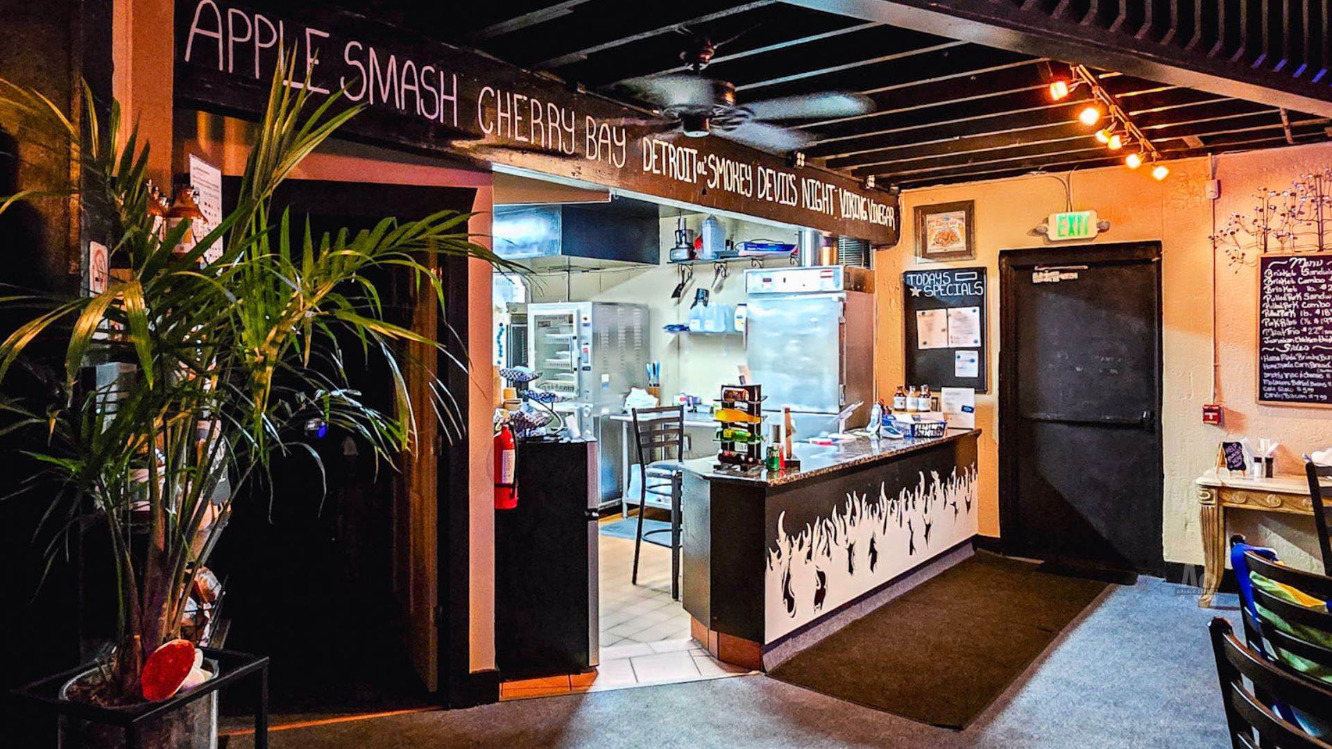 The Blue Kuna Smokehouse counter in Plymouth with the sauce lineup chalked above the pass